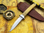 UA Iron Fang stainless steel camping knife with a textured black handle and sharp blade, ideal for outdoor camping and survival.