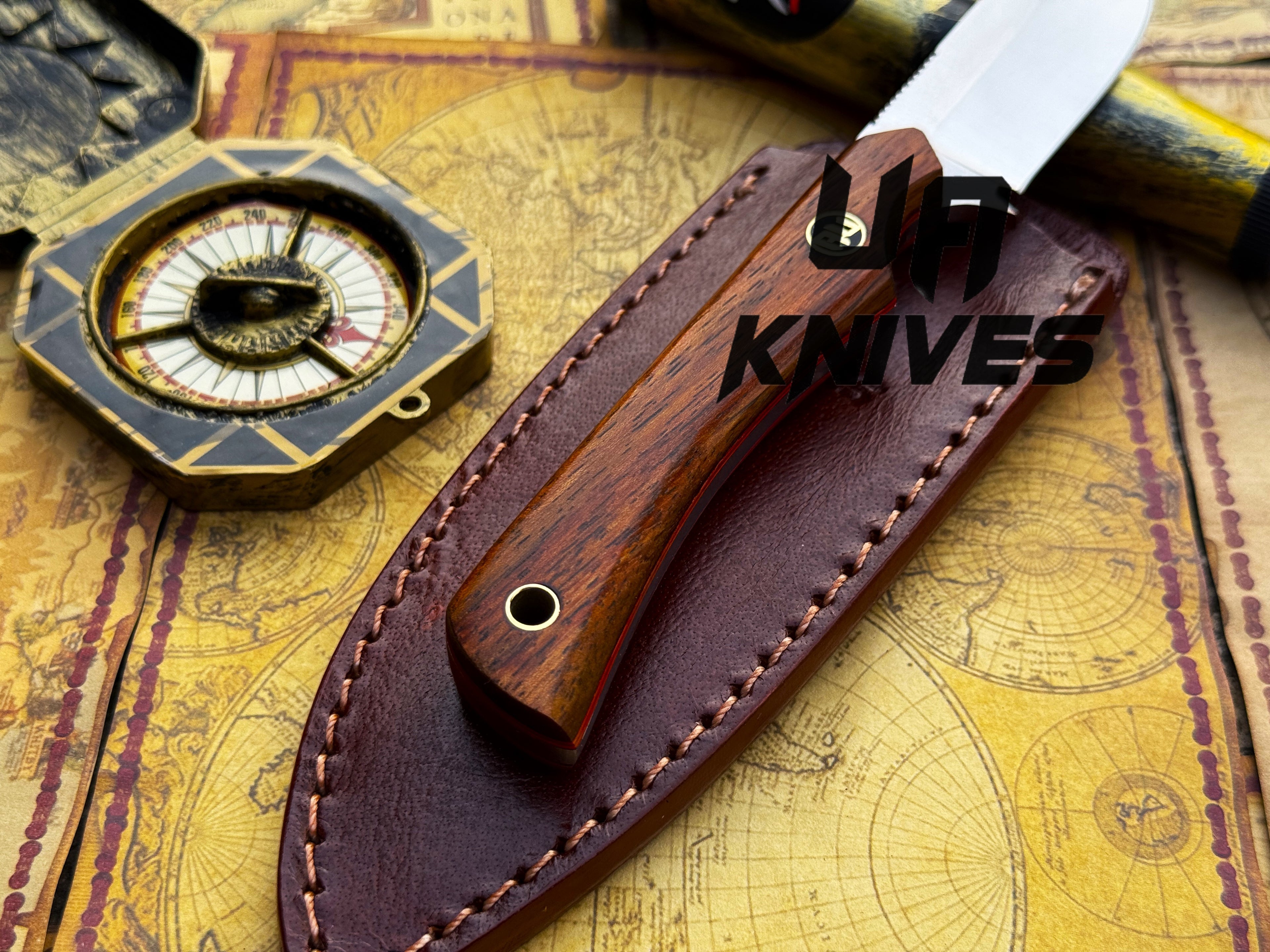UA Cobra Strike camping knife by UA Knives with handmade lightweight design and sheath, displayed on a neutral background.