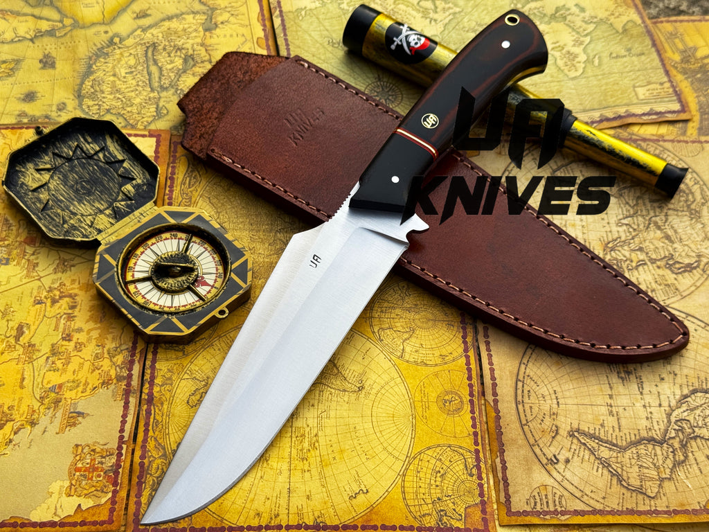 UA Knives Dragons Tooth handmade Bowie hunting knife with leather sheath, featuring a detailed blade and rustic wooden handle.
