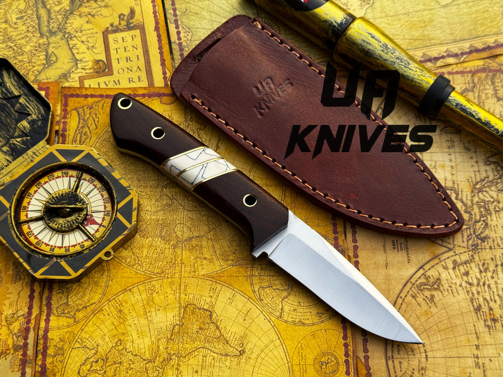 UA Knives Silver Myst stainless steel camping skinning knife with sheath, featuring a sharp blade and ergonomic handle.