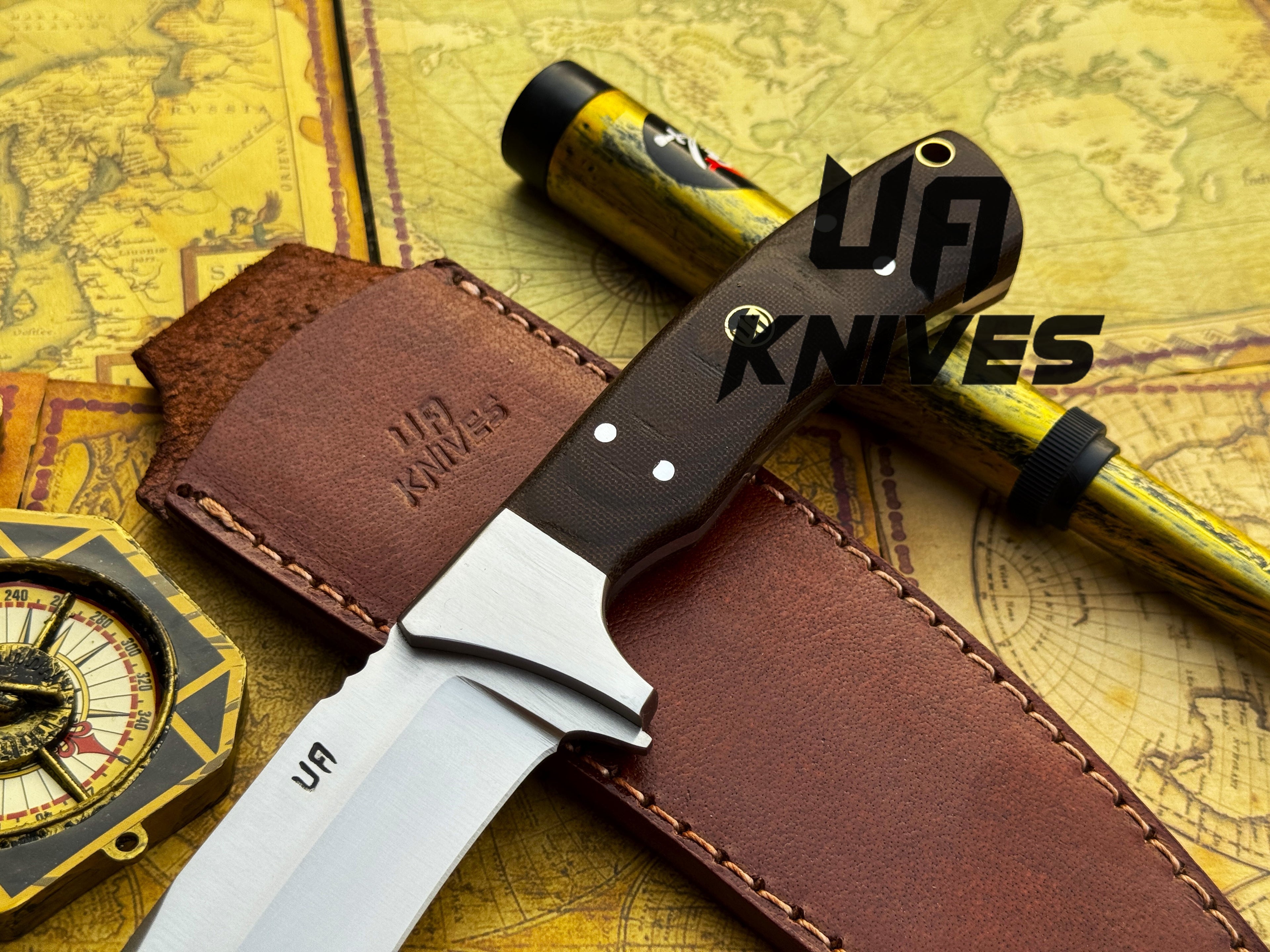 UA Knives Bear Claw hunting knife with hand-forged blade and G10 Micarta handle, displayed on a wooden surface.