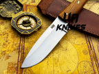 UA Knives Nature Nook hunting knife with a hand-forged stainless steel blade and textured handle, displayed on a wooden surface.