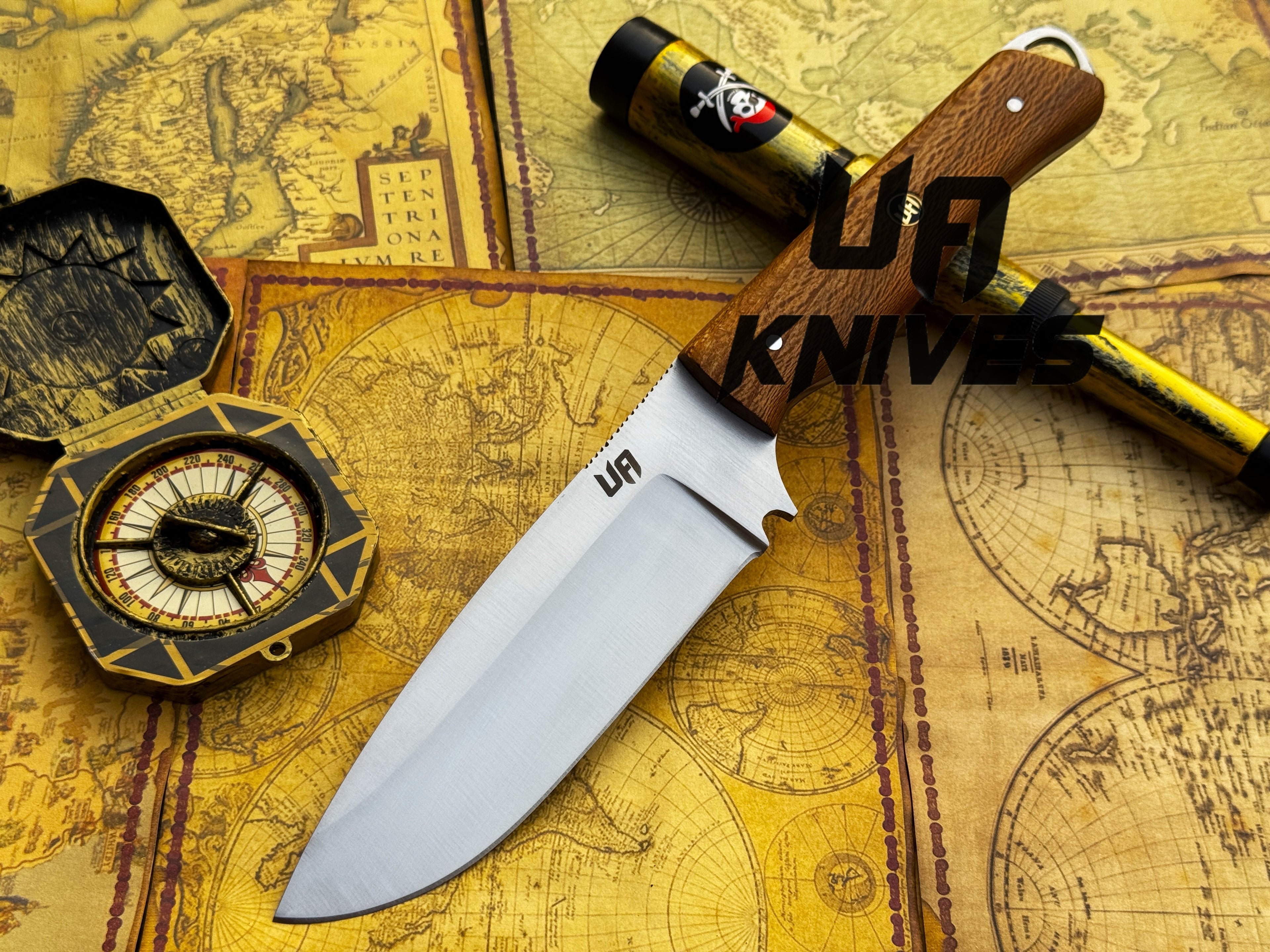 UA Nature Nook hand-forged stainless steel hunting knife with a leather handle, displayed on a wooden surface.
