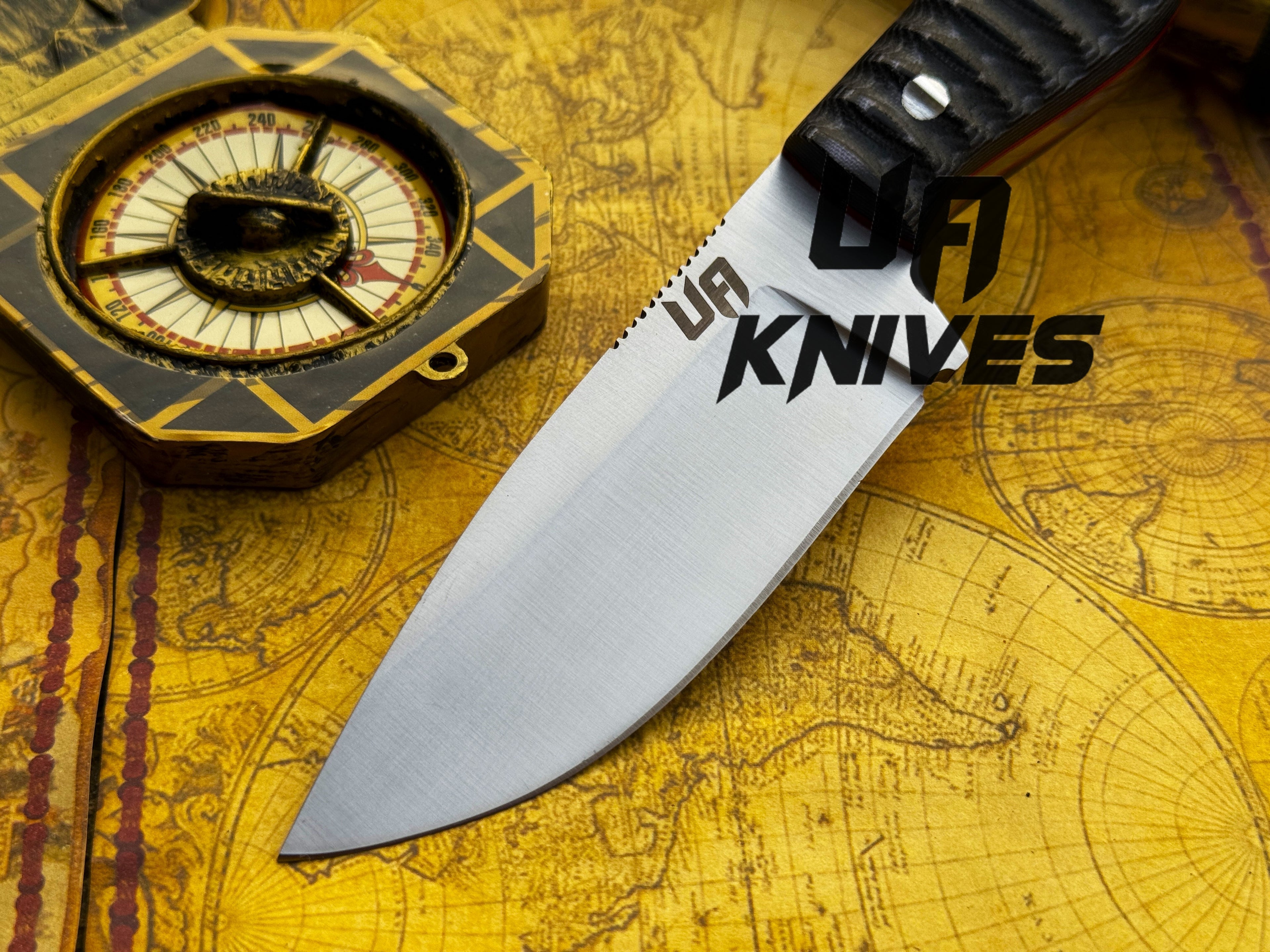 UA Knives Silver Myst hunting knife with hand-forged 12C27 blade and sheath, featuring a sleek silver handle and sturdy design.