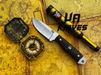 UA Silver Myst hunting knife by UA Knives, hand-forged 12C27 steel with a leather sheath, shown on a rustic surface.