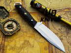 UA Knives Night Stalker hunting knife with 12C27 stainless steel blade and black handle, displayed on a wooden surface.