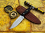 UA Knives Night Stalker hunting knife with a 12C27 stainless steel blade and black handle, shown on a plain background