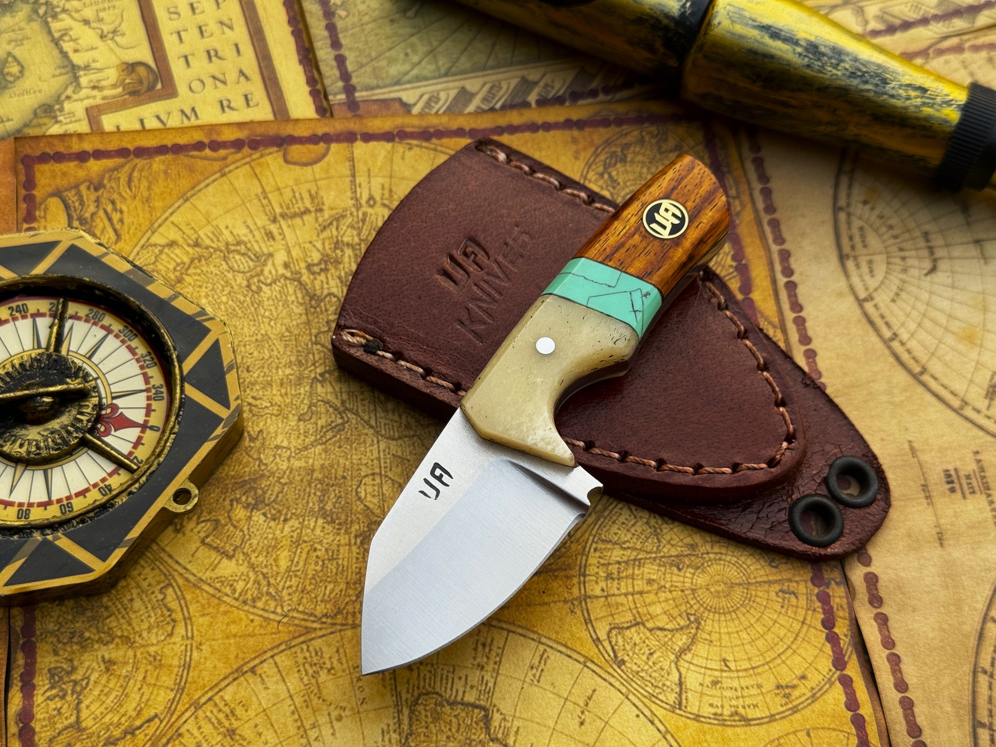 Knife with wooden handle and leather sheath on an old map