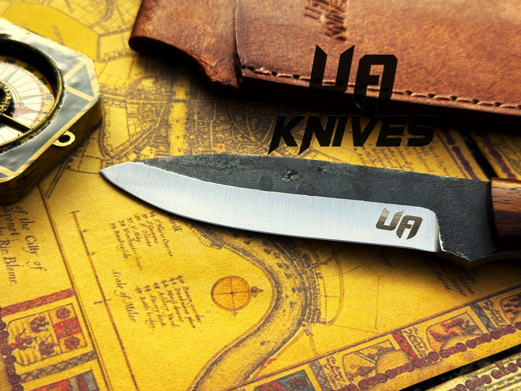 UA Knives True Guide camping knife with hand-forged Scandinavian blade and ergonomic rosewood handle, ideal for bushcraft camping.